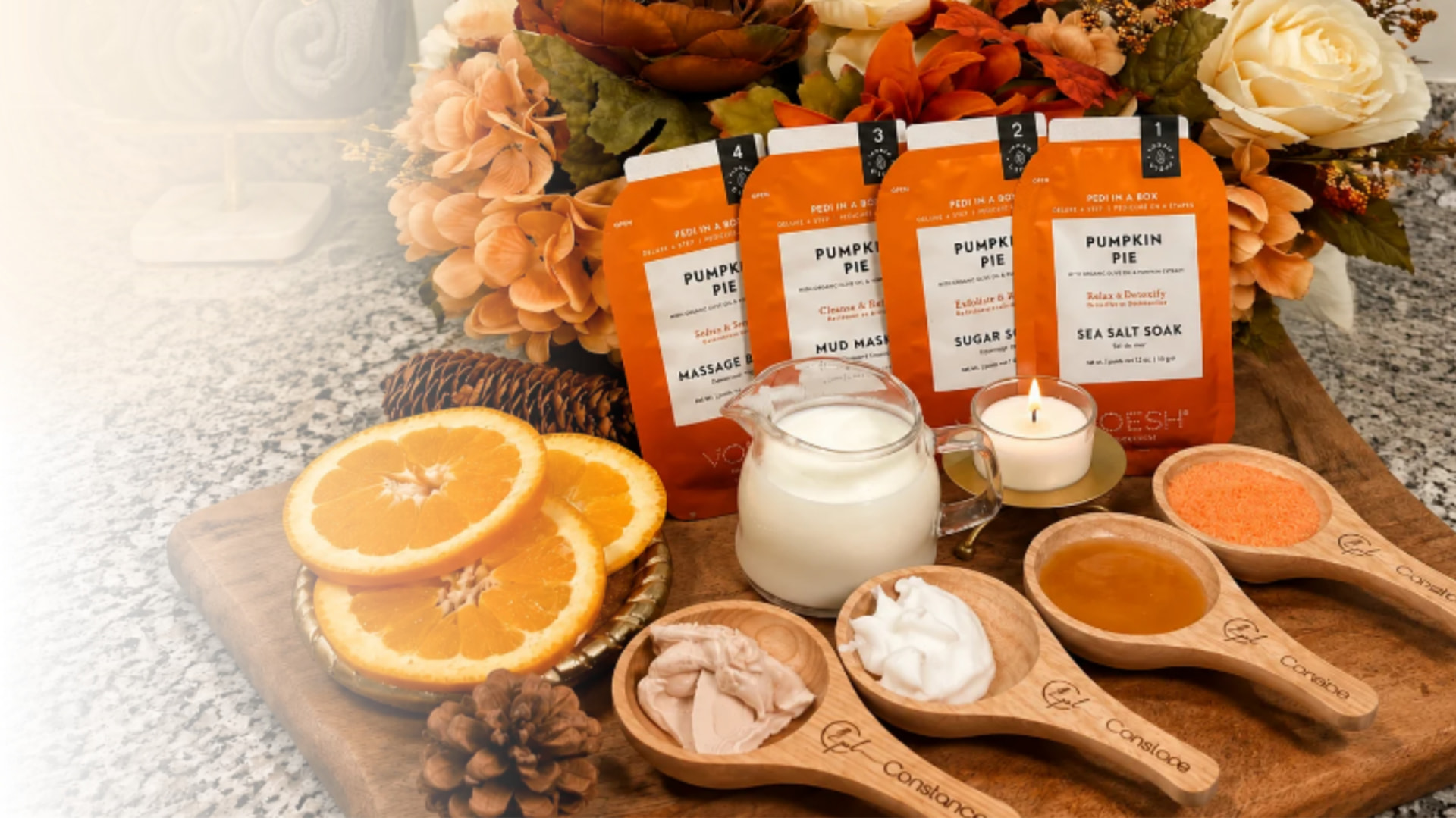 Pumpkin Pie Pedi in a Box products with orange slices and wooden spoons